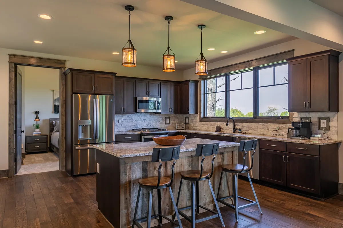 A spacious kitchen with a central island, stools, and a large window offering scenic mountain views. The space is bright and ideal for gathering, cooking, or simply sipping morning coffee while appreciating the natural surroundings.